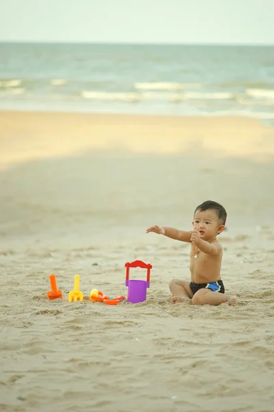 Liten asiatisk pojke 1 år gammal spelar sand på stranden — Stockfoto