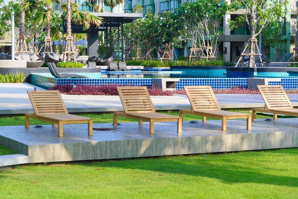 Strandstoelen in de buurt van zwembad in tuin — Stockfoto