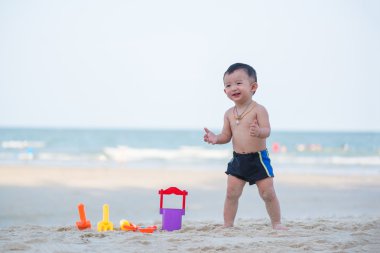 Küçük Asyalı çocuk 1 yaşında iskambil kum plaj