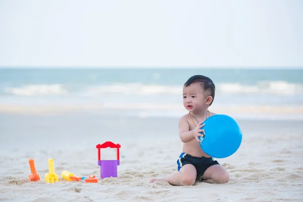 Pequeno menino asiático 1 ano de idade jogando bola na praia — Fotografia de Stock