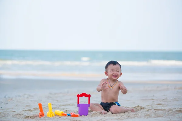 Petit garçon asiatique de 1 an jouant au sable sur la plage — Photo