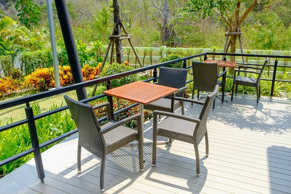 Столы и стул в пустом кафе возле сада — стоковое фото