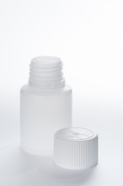 Gri arka plan üzerinde beyaz plastik tıbbi ambalaj şişe