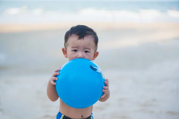Liten asiatisk pojke 1 år gammal spelar boll på stranden — Stockfoto