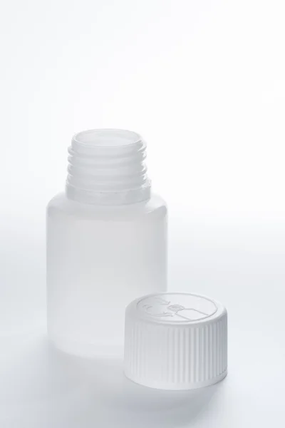 Bílé plastové zdravotní kontejner láhev na šedém pozadí — Stock fotografie