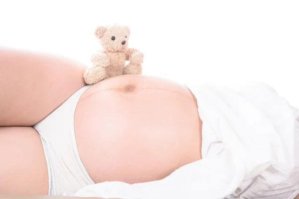 Pregnant woman with hands and have bear doll — Stock Photo, Image