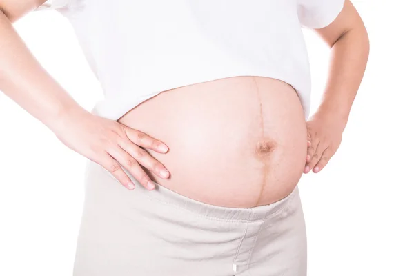 Schwangere umarmt ihren Bauch vor nacktem Hinterleib im achten Monat — Stockfoto