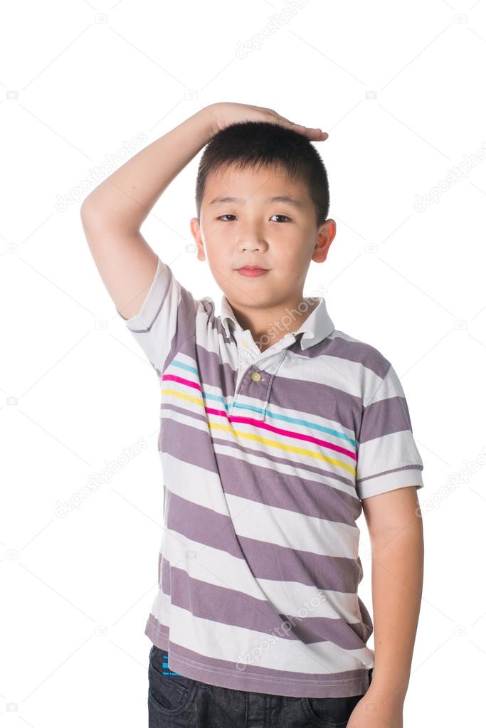 Boy growing tall and measuring himself, isolated on white backgr