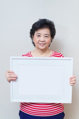 Asyalı kadın boş beyaz resim çerçevesi studio tutarak atış, sp