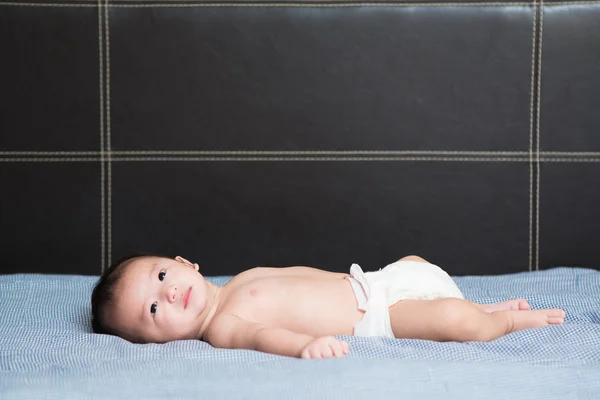 Cute Asian baby lying on bed, Shallow DOF, focus on eyes. — Stock Photo, Image