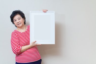 Asyalı kadın boş beyaz resim çerçevesi studio tutarak atış, sp