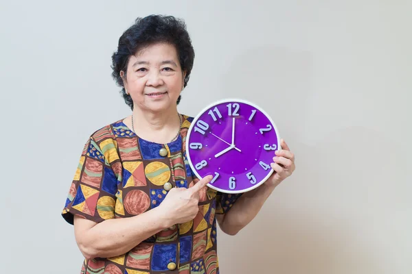 Asijské starší žena držící fialové hodiny ve studiu zastřelil, specialt — Stock fotografie