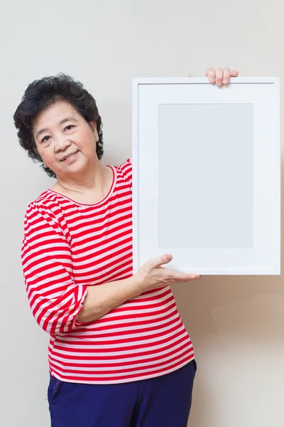 Asian woman holding empty white picture frame in studio shot, sp — Stock Photo, Image