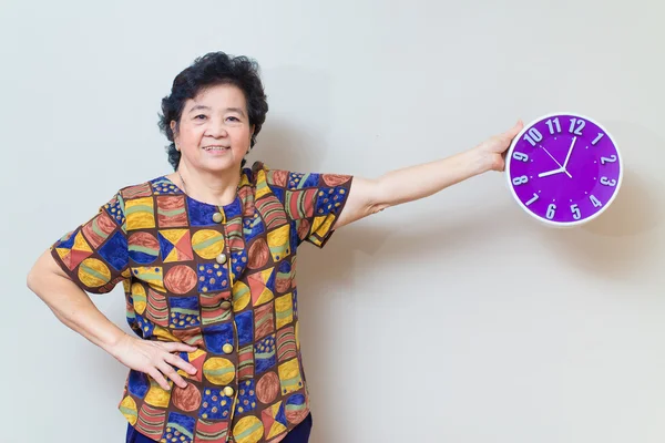 Asijské starší žena držící fialové hodiny ve studiu zastřelil, specialt — Stock fotografie