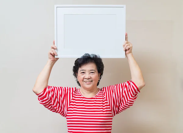 Asian woman holding empty white picture frame, warm tone — Stock Photo, Image