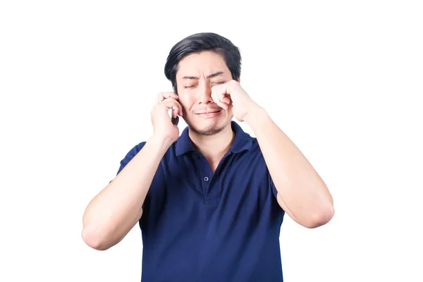 Азиатский парень с мобильным телефоном в руке и плачет, изолированный от реальности — стоковое фото