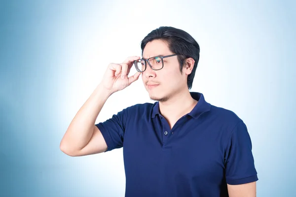 Snygg asiatisk man tittar upp medan du håller glasögon med hand, o — Stockfoto