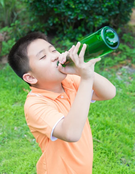 Asijské boy pitné vody ze zelené láhve — Stock fotografie