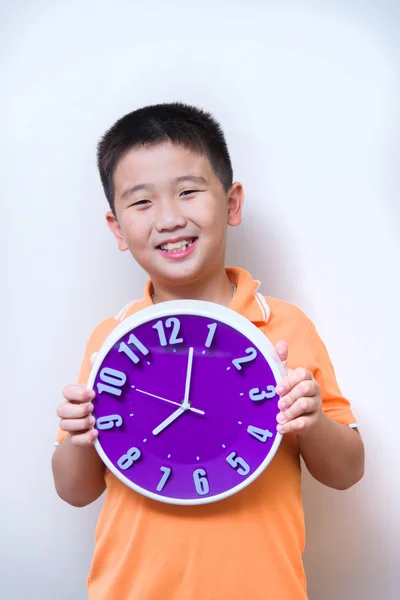 Asian boy showing and holding purple or violet clock in studio s — Stock Photo, Image