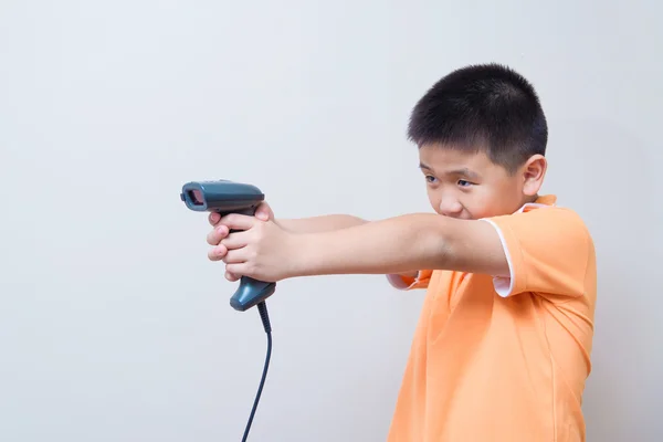 Niño asiático apuntar una pistola falsa hecha con escáner de código de barras —  Fotos de Stock