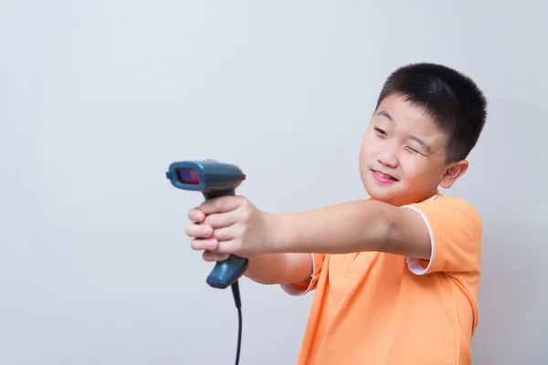 アジアの少年は、バーコード スキャナーで作られた偽銃を目指してください。 — ストック写真