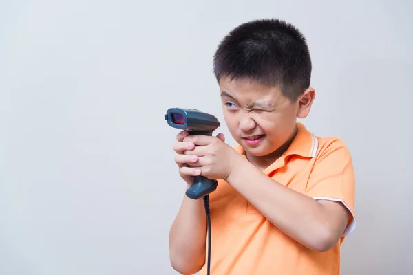 Niño asiático apuntar una pistola falsa hecha con escáner de código de barras — Foto de Stock