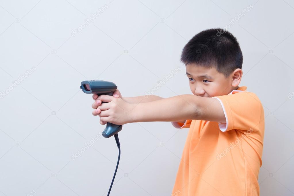 Asian boy aim a fake gun made with barcode scanner