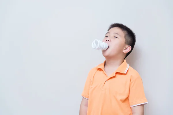 Energy saving lamp in Asian boy mouth — Stock Photo, Image