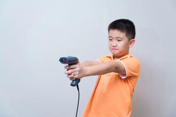 Asiatischer Junge zielt mit Barcode-Scanner auf gefälschte Waffe — Stockfoto