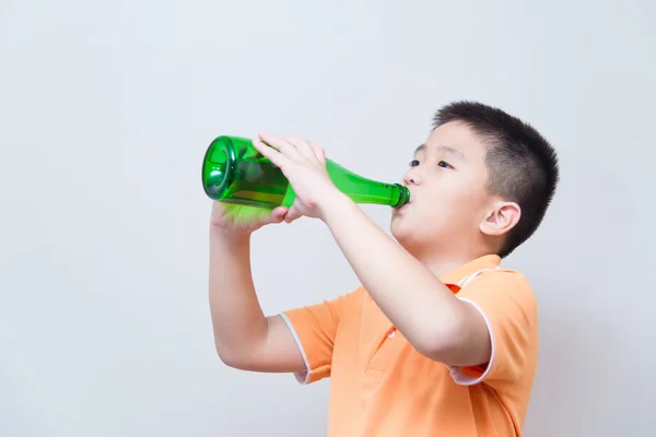 Asijské boy pitné vody ze zelené láhve — Stock fotografie