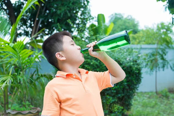 Asiatico ragazzo bere acqua da verde bottiglia — Foto Stock