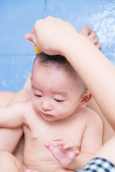 Mãe dar um banho seu bebê no banheiro — Fotografia de Stock