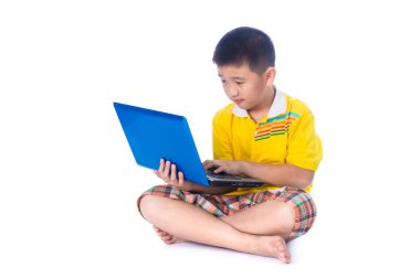 Asyalı çocuk beyaz zemin üzerine oturan bir dizüstü bilgisayar kullanarak ayrı tut