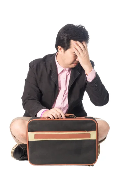 Worried young businessman with briefcase sitting, isolated on wh Stock Photo