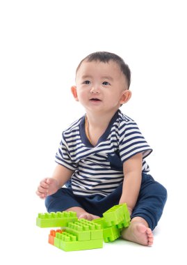 Asya bebek üzerinde beyaz plastik inşaat oyuncaklar ile oynama 