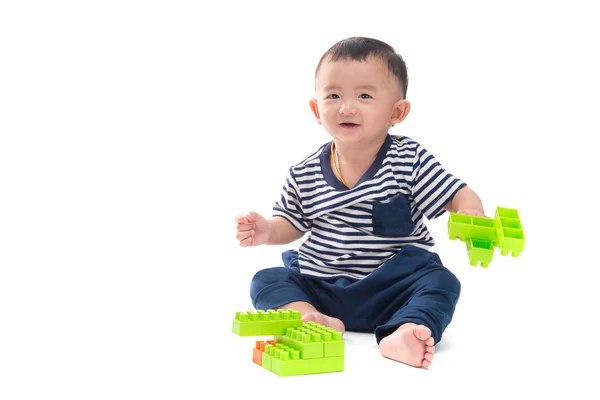 Asijské dítě hraje s hračkami, plastová konstrukce nad bílá — Stock fotografie