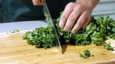 Şef salatayı yavaş çekimde keser, şef salata yapar, salatayı yakın çekimde keser.