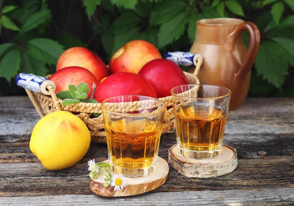 Яблочный сок в двух стаканах на старом деревянном столе — стоковое фото