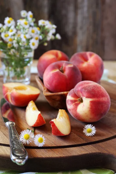 Fresh peaches and wildflowers — Stock Photo, Image