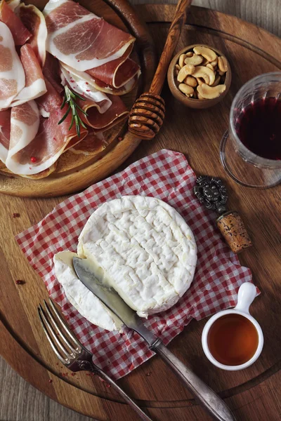 Camembert cheese, cold cuts and red wine — Stock Photo, Image