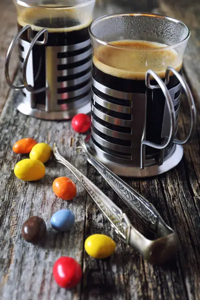 Black coffee and multicolored candy — Stock Photo, Image