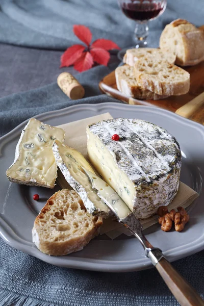 Французский сыр из коровьего молока, красные груши и винное стекло — стоковое фото