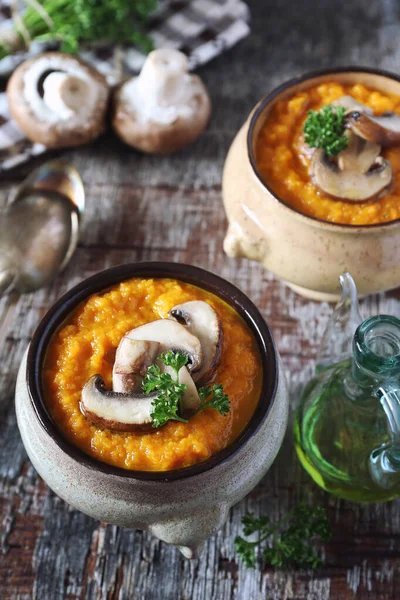 Vegetable carrot soup puree with mushroom and parsley dressing in two ceramic tureen. Rustic style — Stock Image Vegetable Carrot Soup Puree Mushroom Parsley Dressing Two Ceramic Tureen Royalty Free Stock Photos