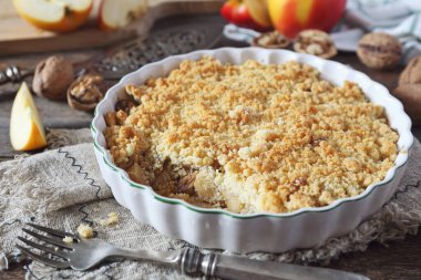 Ahşap arka planda ceviz ve tarçınlı elma parçacıkları, köy tarzı.