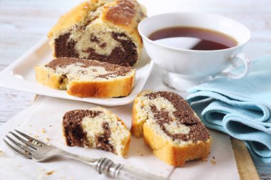 Ev yapımı mermer pasta ve arka planda bir fincan siyah çay.