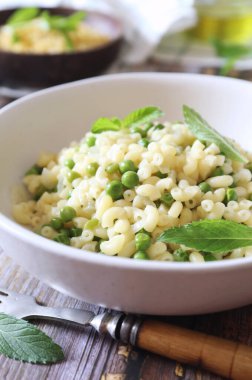 İtalyan mutfağı. Sahte risotto. Yeşil bezelyeli Stortini makarna ve kızarmış soğan, naneli garnitür. 