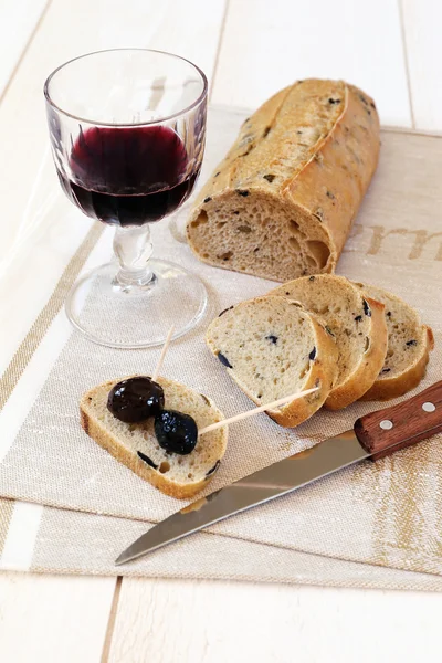 French bread with olives, Provencal olives and a glass of red wi — Stock Photo, Image