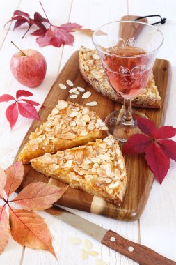 Sonbahar ruh hali: elmalı tart, renkli yaprakları ve bir bardağı 