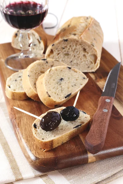 French bread with olives, Provencal olives and a wineglass — Stock Photo, Image