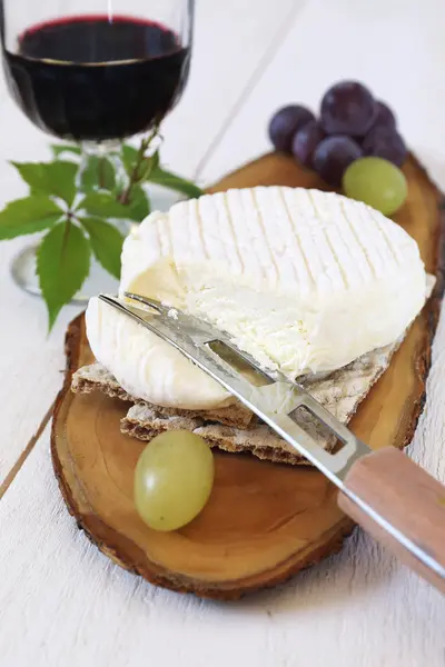 Queso de cabra francés, uvas y copa de vino tinto — Foto de Stock